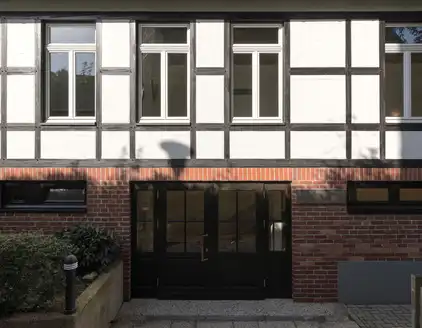 Dunkle Eingangstür, Fachwerk an oberer Etage