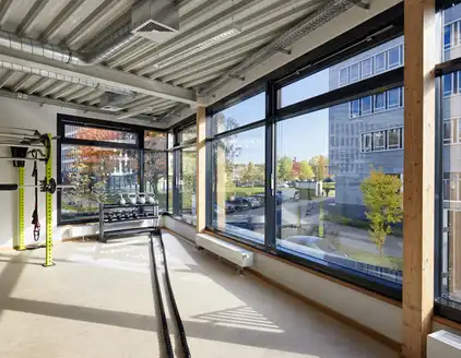 kleiner Fitnessraum mit Fensterfront und Sportgräten