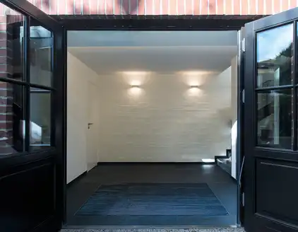 weißer Vorraum mit dunklem Steinboden, Treppe rechts