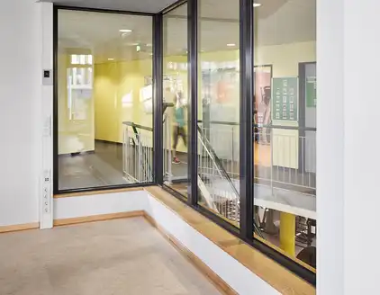 innen Fensterfront mit Blick auf den Flur mit Treppe