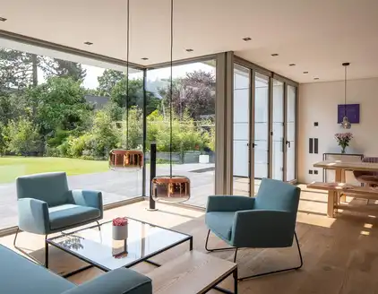 Wohn- Esszimmer mit Sofagarnitur, Fensterfront Blick auf die Terrasse und Garten