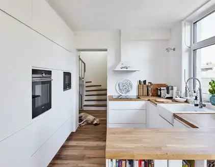 helle Küche mit Holz Anrichte und Blick auf Treppe