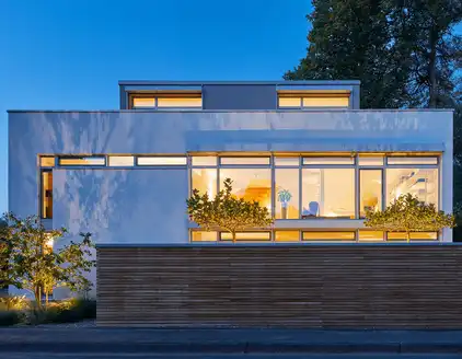 Gebäude, teilweise mit Holzfassade, erleuchtete Fenster