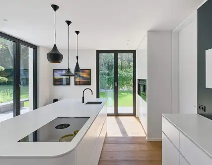 Küche mit Kücheninsel und Hängelampen, Fenster in den Garten