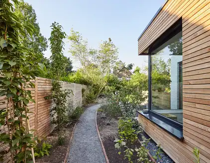 Begrünter Weg neben dem Haus zum Garten