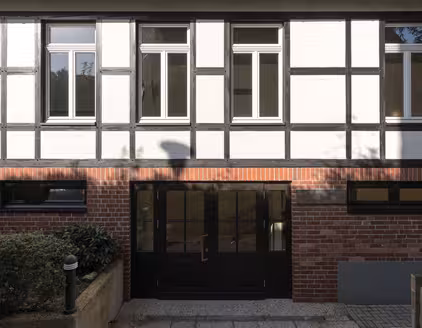 Dunkle Eingangstür, Fachwerk an oberer Etage