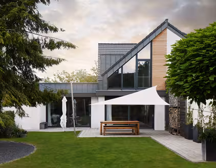 doppelstöckiges Gebäude mit Fensterfront: Sicht aus dem Garten am Tag