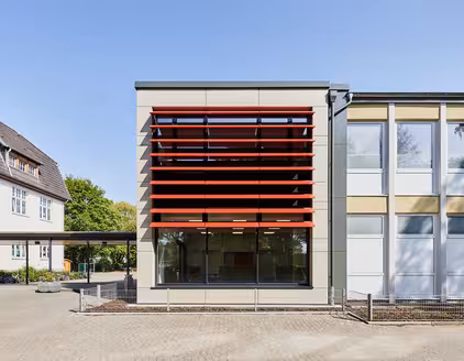 Schule mit roten Lamellen an Fensterfront