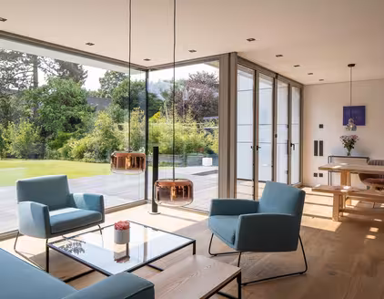 Wohn- Esszimmer mit Sofagarnitur, Fensterfront Blick auf die Terrasse und Garten