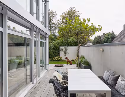 Terrasse vor der zweistöckigen Fensterfront