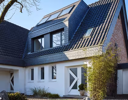 Weißes Haus mit dunkel blauem Spitzdach