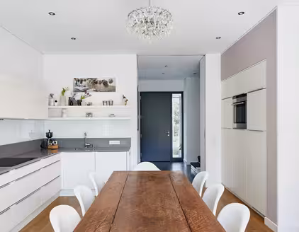 helle Küche mit Tischgarnitur und Anrichte links