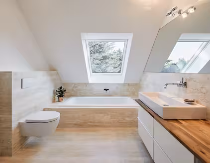 helles Badezimmer mit Toilette links und Holzanricht mit Waschbecken rechts