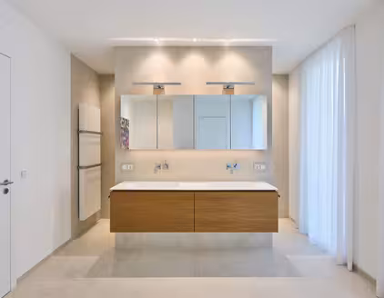 Badezimmer mit Waschbeckenanrichte in der Mitte