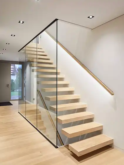 Flur mit schwebender Holztreppe und Glasabtrennung