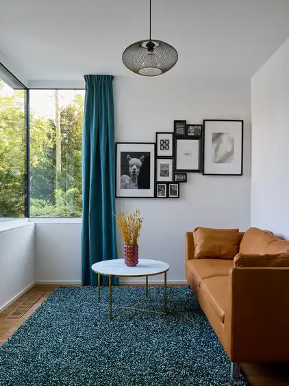 weißer Raum mit Sofa rechts, Fenster über Eck links