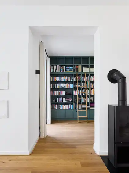 Blick in einen Raum mit einem hohen Bücherregal