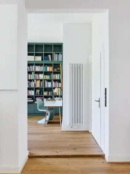 Blick in einen Raum mit einem hohen Bücherregal