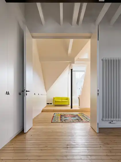 Raum im Dachgeschoss mit offener Tür und Holzboden