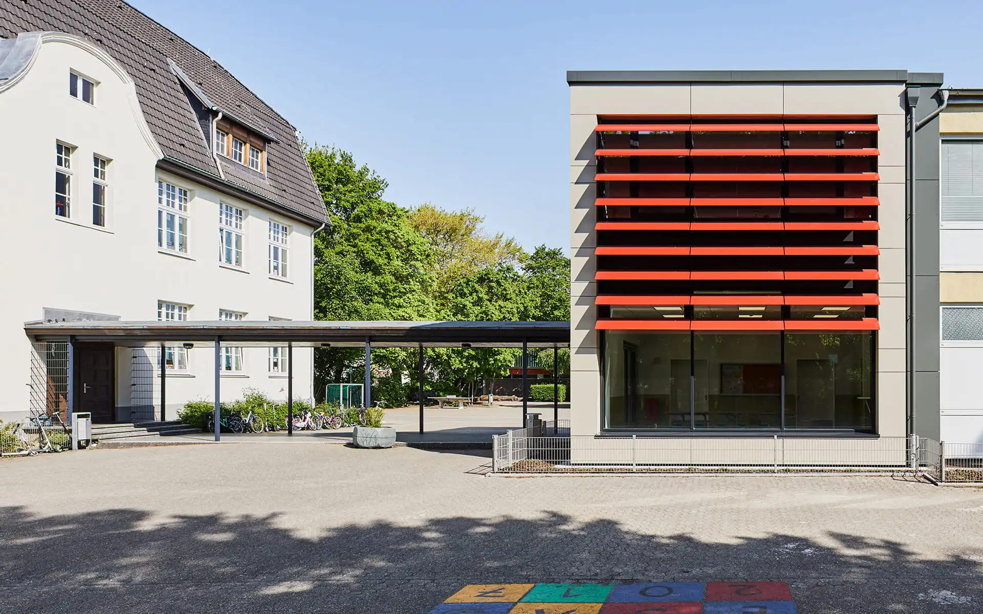 Schule mit roten Lamellen an Fensterfront