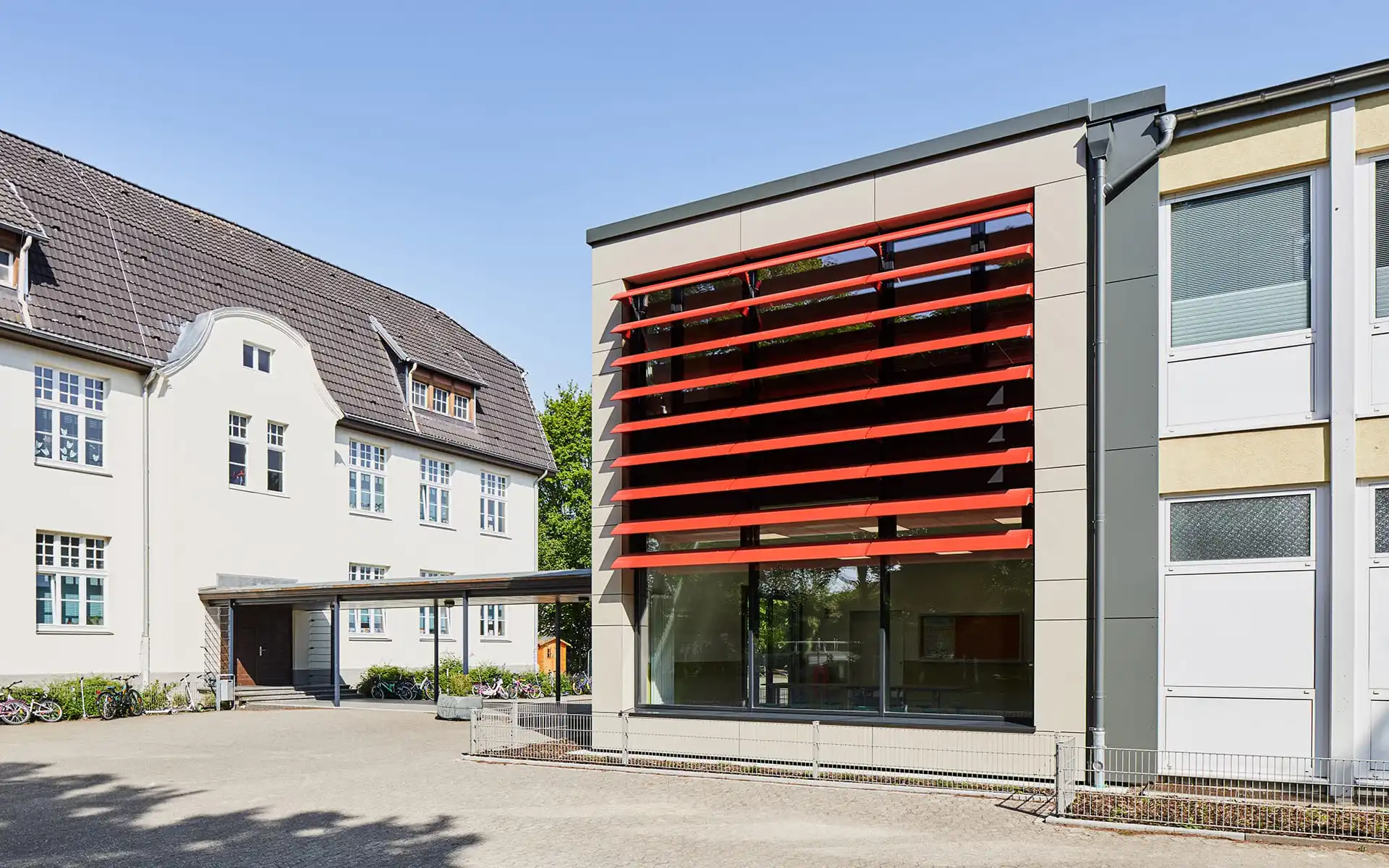 Schule mit roten Lamellen an Fensterfront