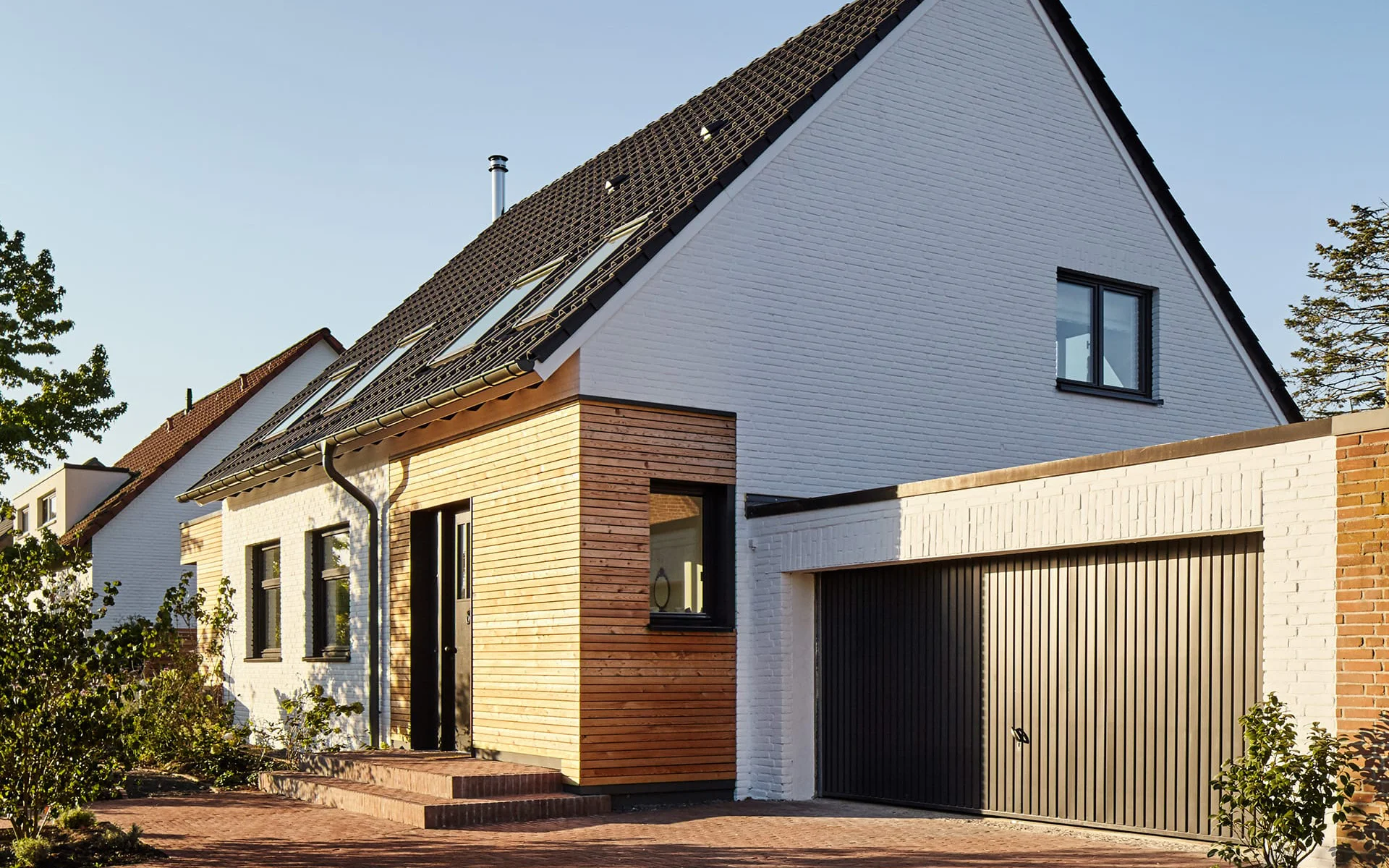 Haus mit Holzfassade am Eingang mit Garage