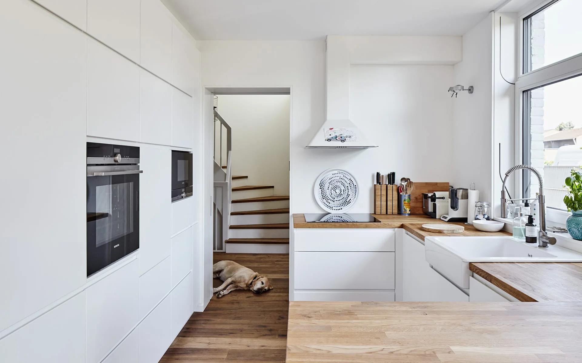 helle Küche mit Holz Anrichte und Blick auf Treppe