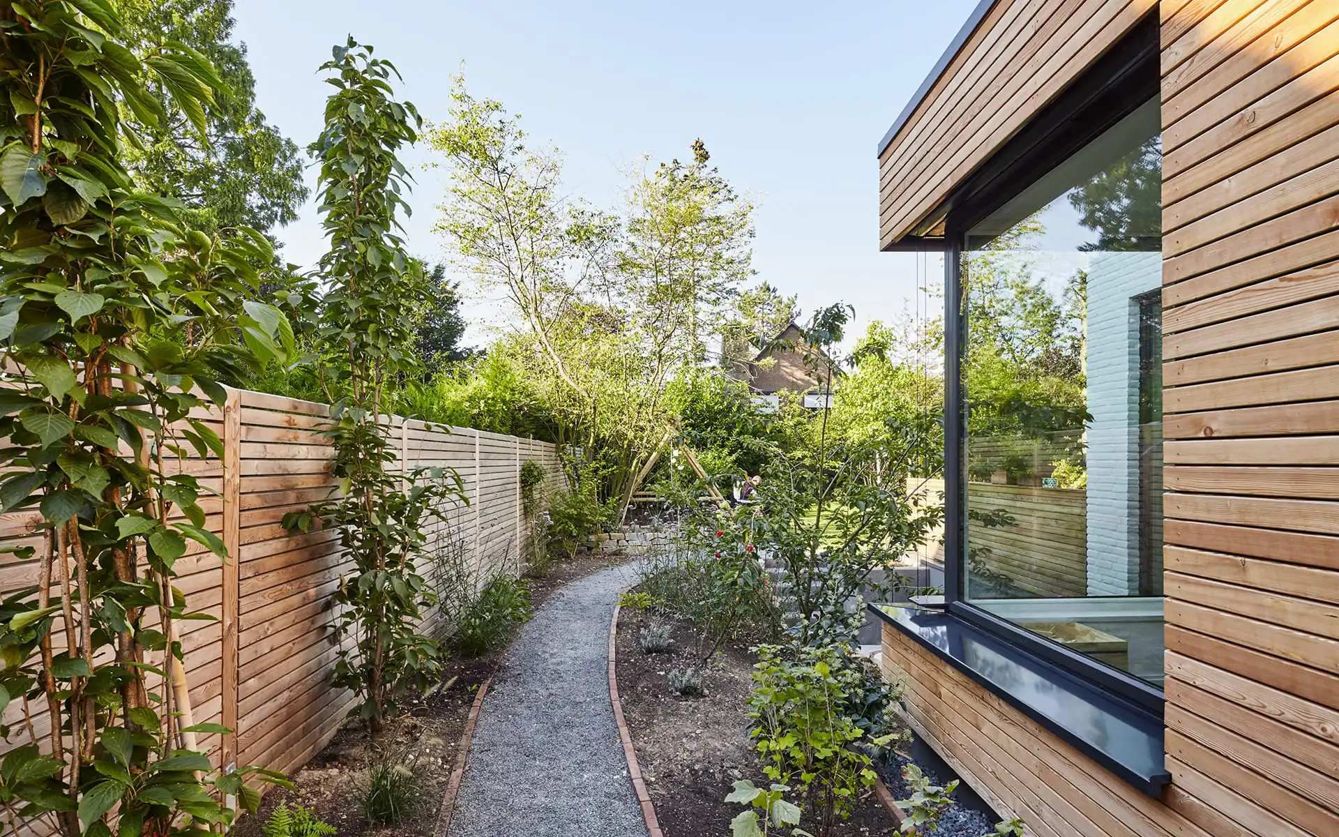 Begrünter Weg neben dem Haus zum Garten