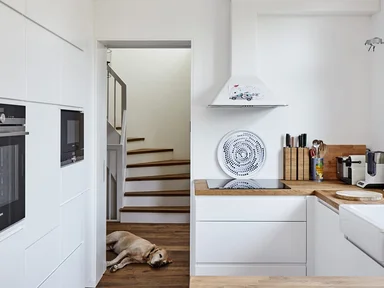 helle Küche mit Holz Anrichte und Blick auf Treppe