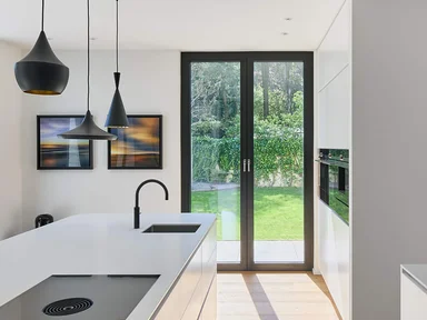Küche mit Kücheninsel und Hängelampen, Fenster in den Garten