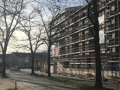 Mehrfamilienhaus im Rohbau mit Gerüst