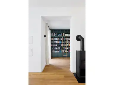 Blick in einen Raum mit einem hohen Bücherregal