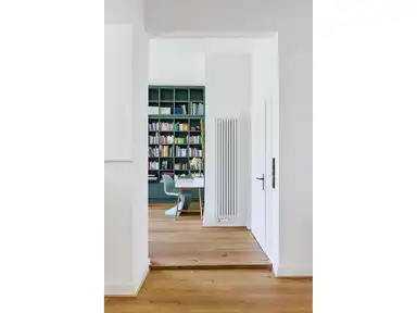 Blick in einen Raum mit einem hohen Bücherregal