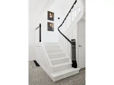 Ein Treppenaufgang mit einer weißen Treppe