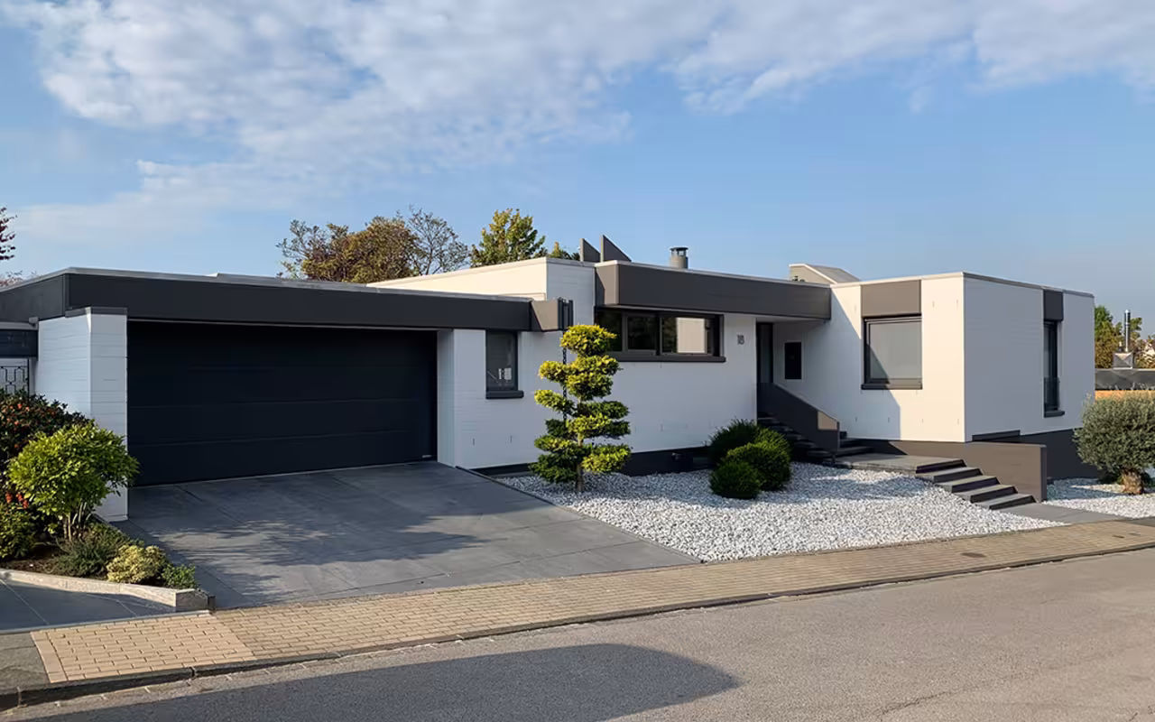 Einstöckiges weißes Haus mit dunklen Akzenten